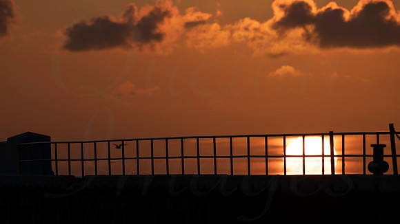 Sunrise over the harbour wall